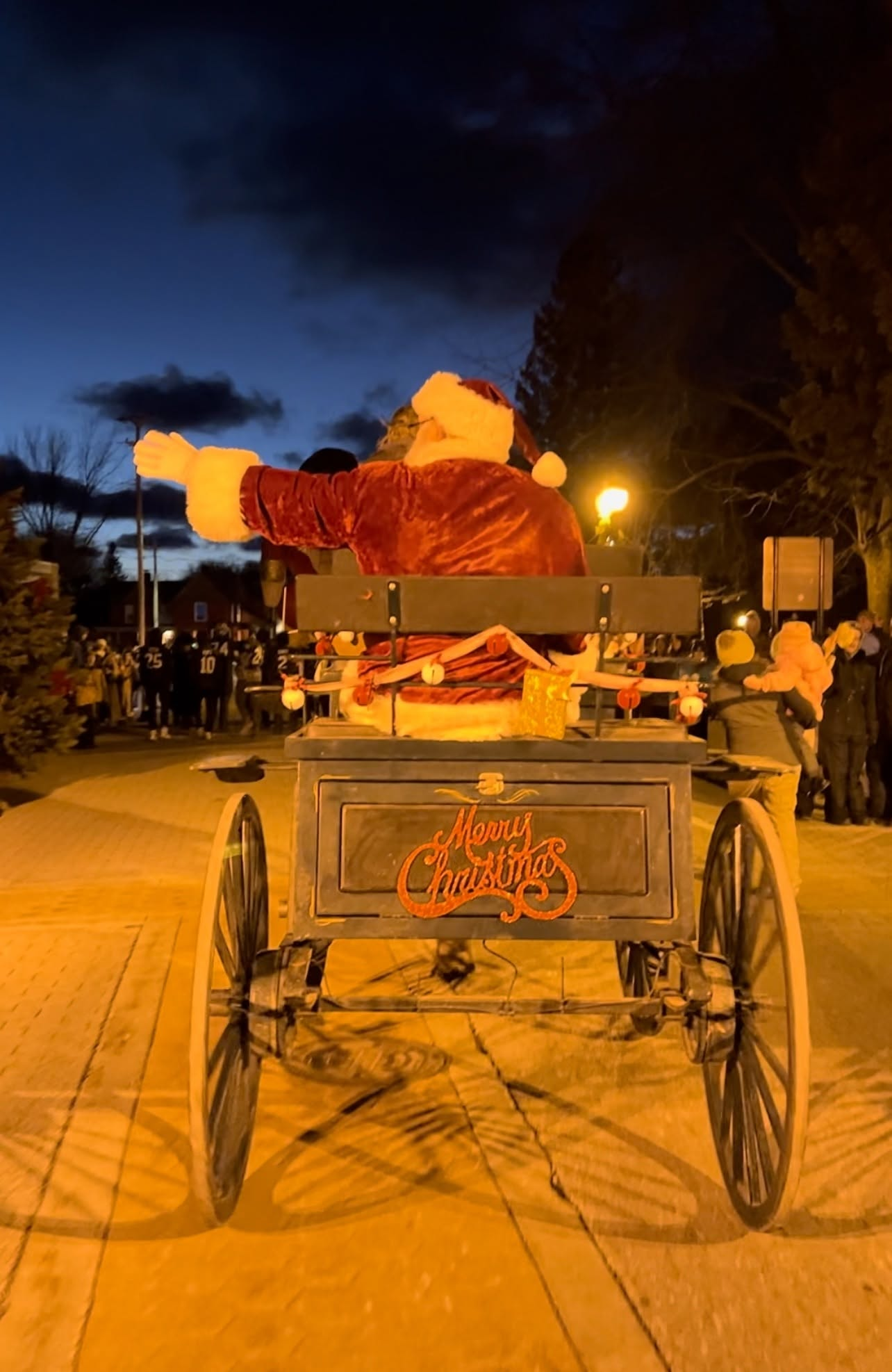 Santa riding through the Manistee Sleighbell Parade in a horse-drawn carriage