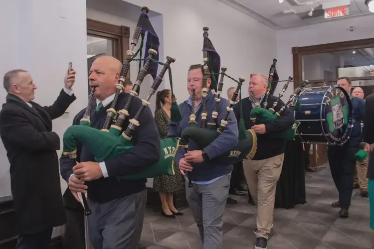 Pipers and drummers parade through City Hall at pre-parade reception