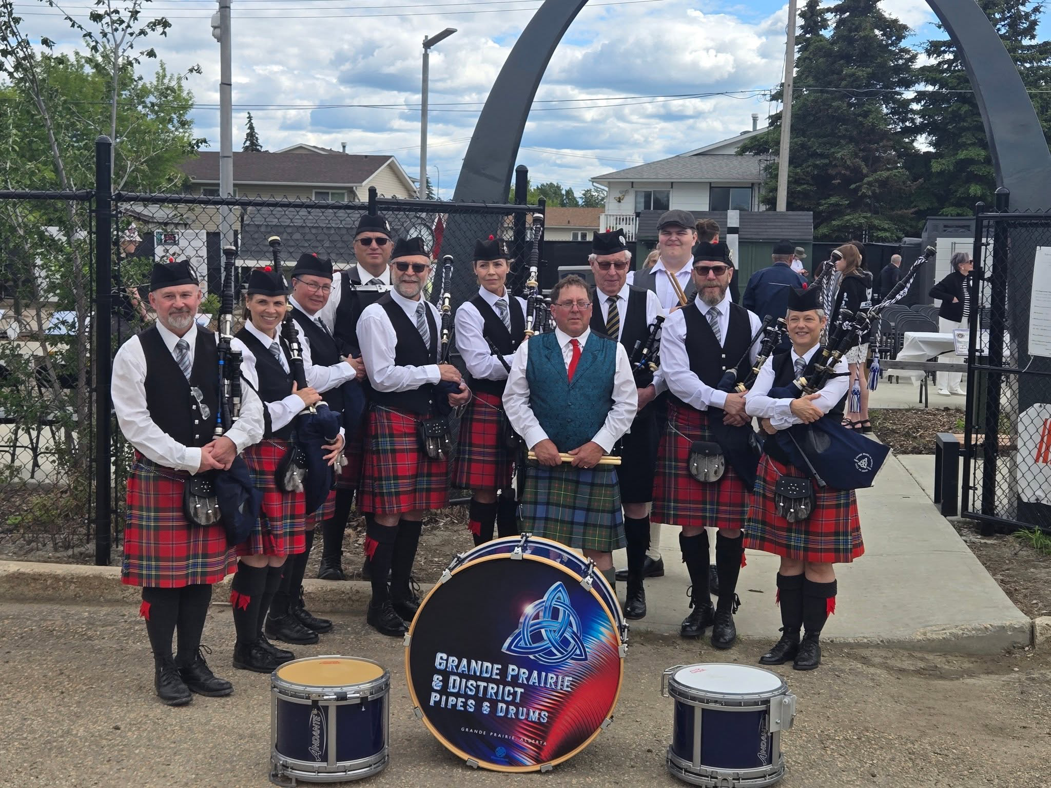 Grande Prairie and District Pipes and Drums posing with their instruments