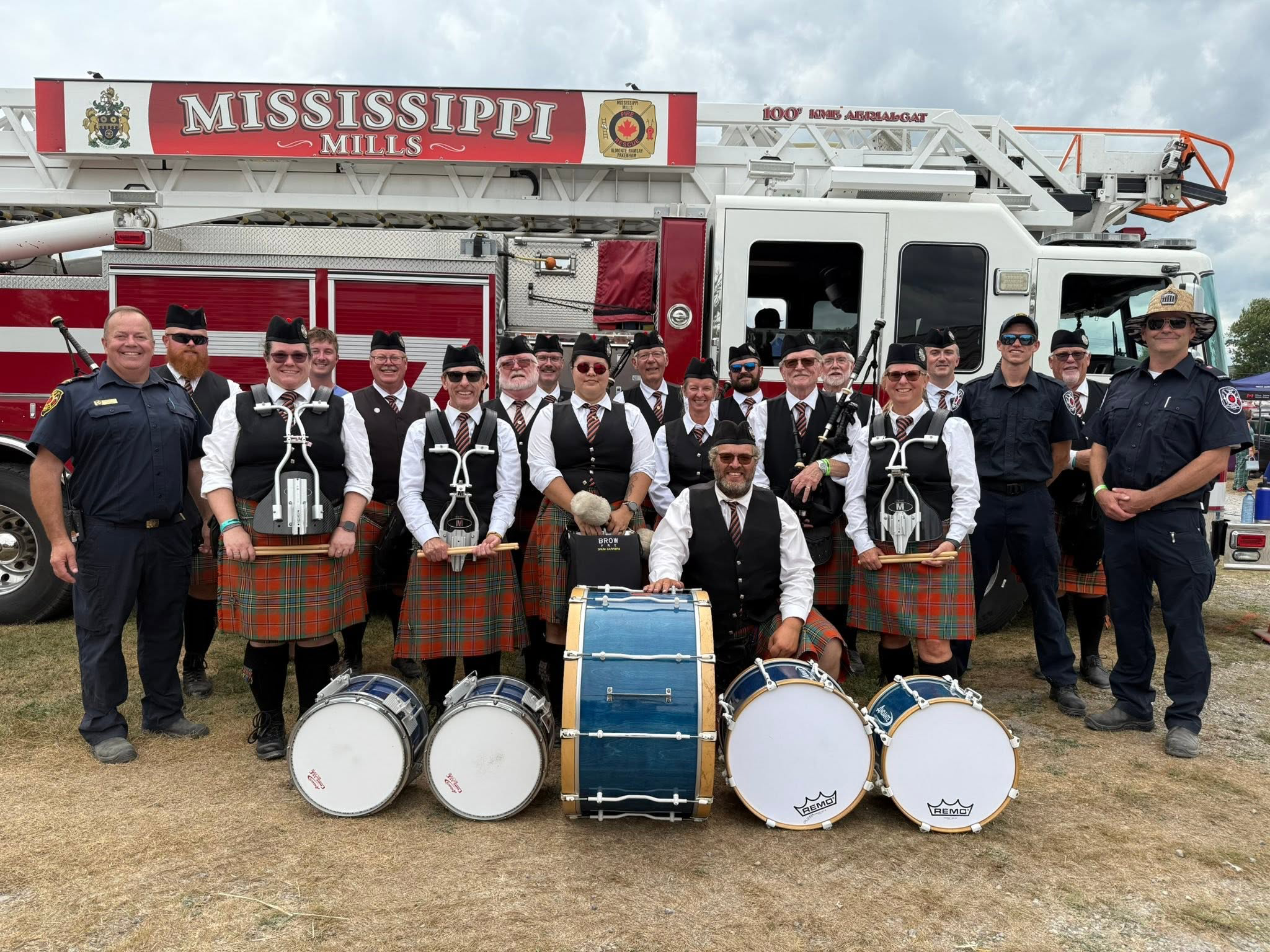 London Fire Fighters Pipe Band members gathered beside a fire engine