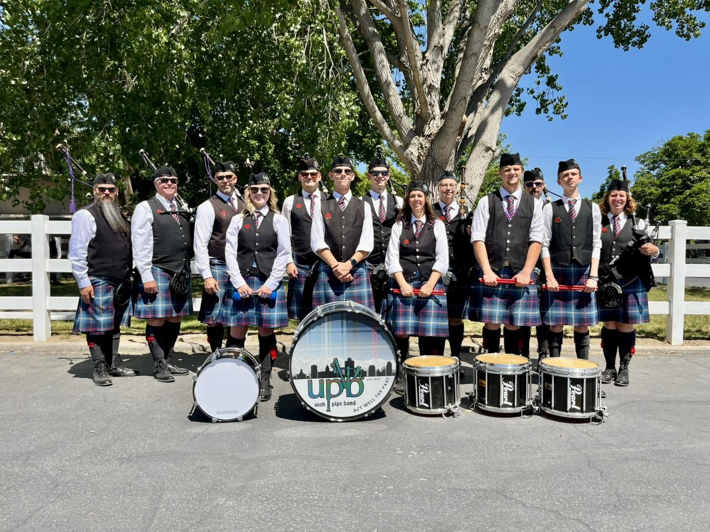 Utah Pipe Band members gathered outdoors with their pipes and drums
